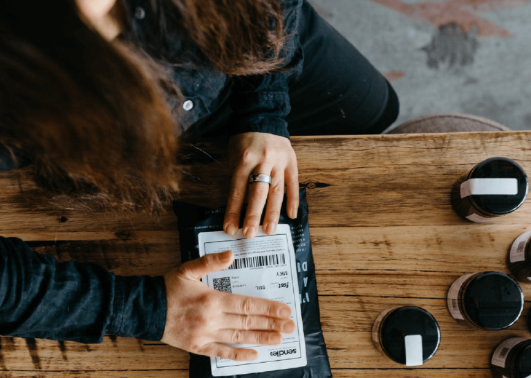 Person using sustainable packaging for small business.